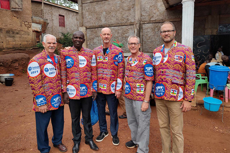 BMM team wearing jackets of fabric specially made for the 100th celebration 11 14 23