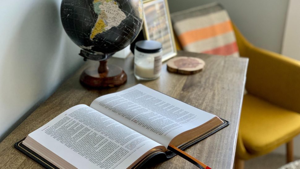 Bible on Table with Globe
